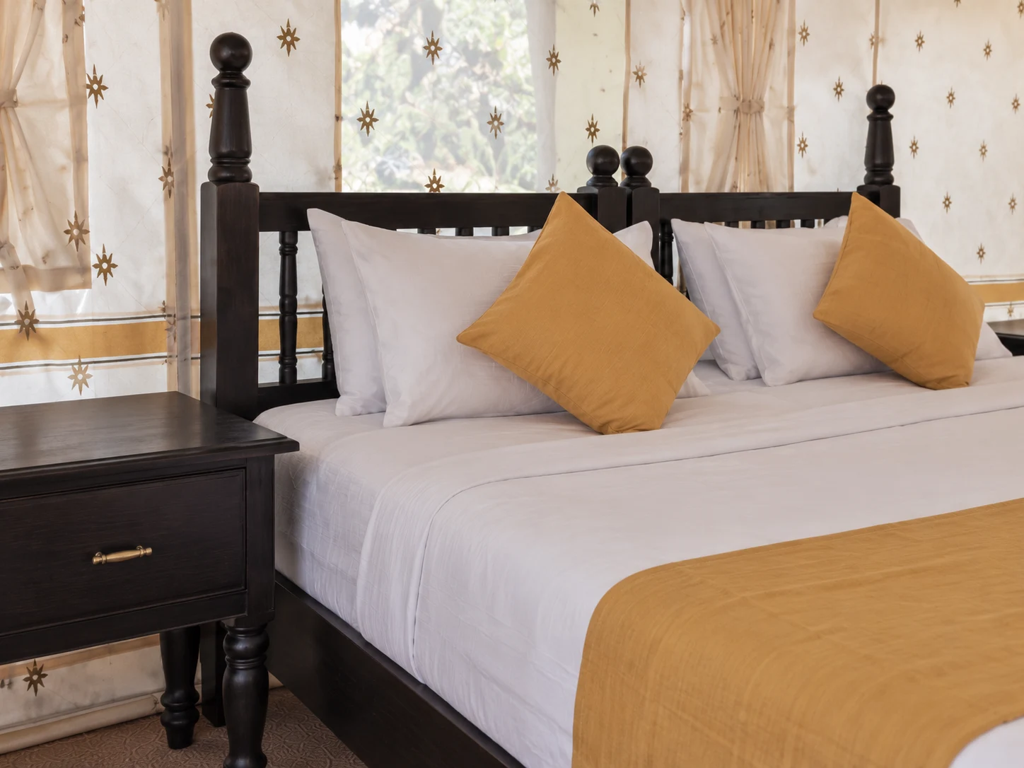 Close-up of the ochre cushion and white bedding