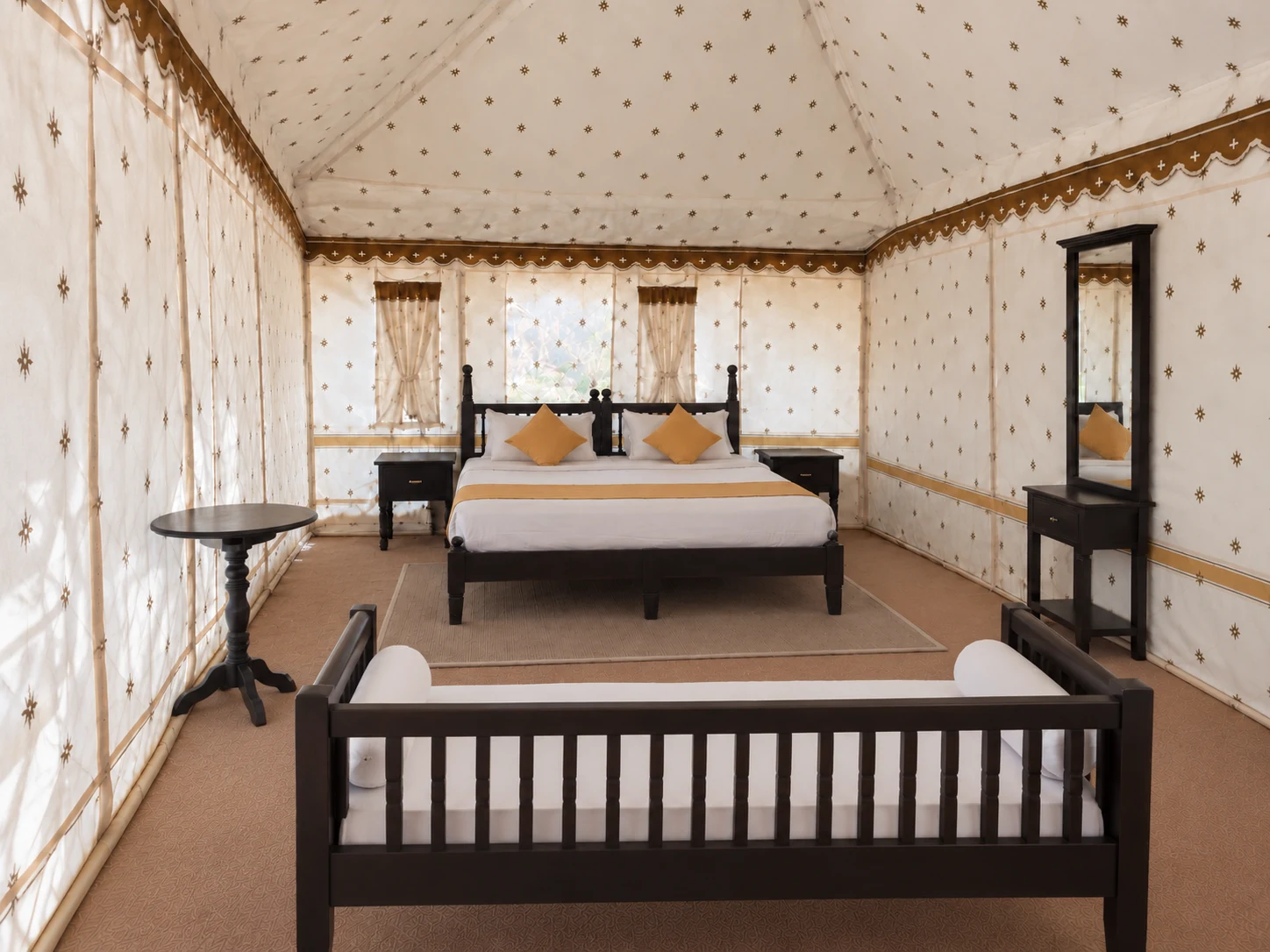 A Namak tent interior with bed, wooden furniture and seating